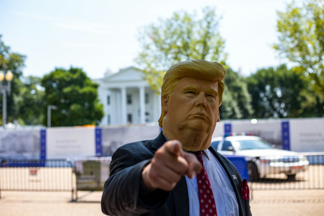 Trump masked pointing fingers at the camera in front of the White House